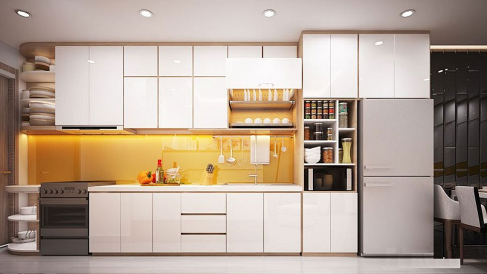 Bếp chữ I thiết kế màu sáng trắng, với hệ thống đèn led âm trần và hệ thống tủ đựng đồ nhỏ, tủ lạnh thiết kế âm tạo nên sự đồng bộ về mặt bằng. Mẫu tủ bếp sử dụng kính màu cam, tạo cảm giác ấn tượng và mới mẻ cho không gian bếp.
